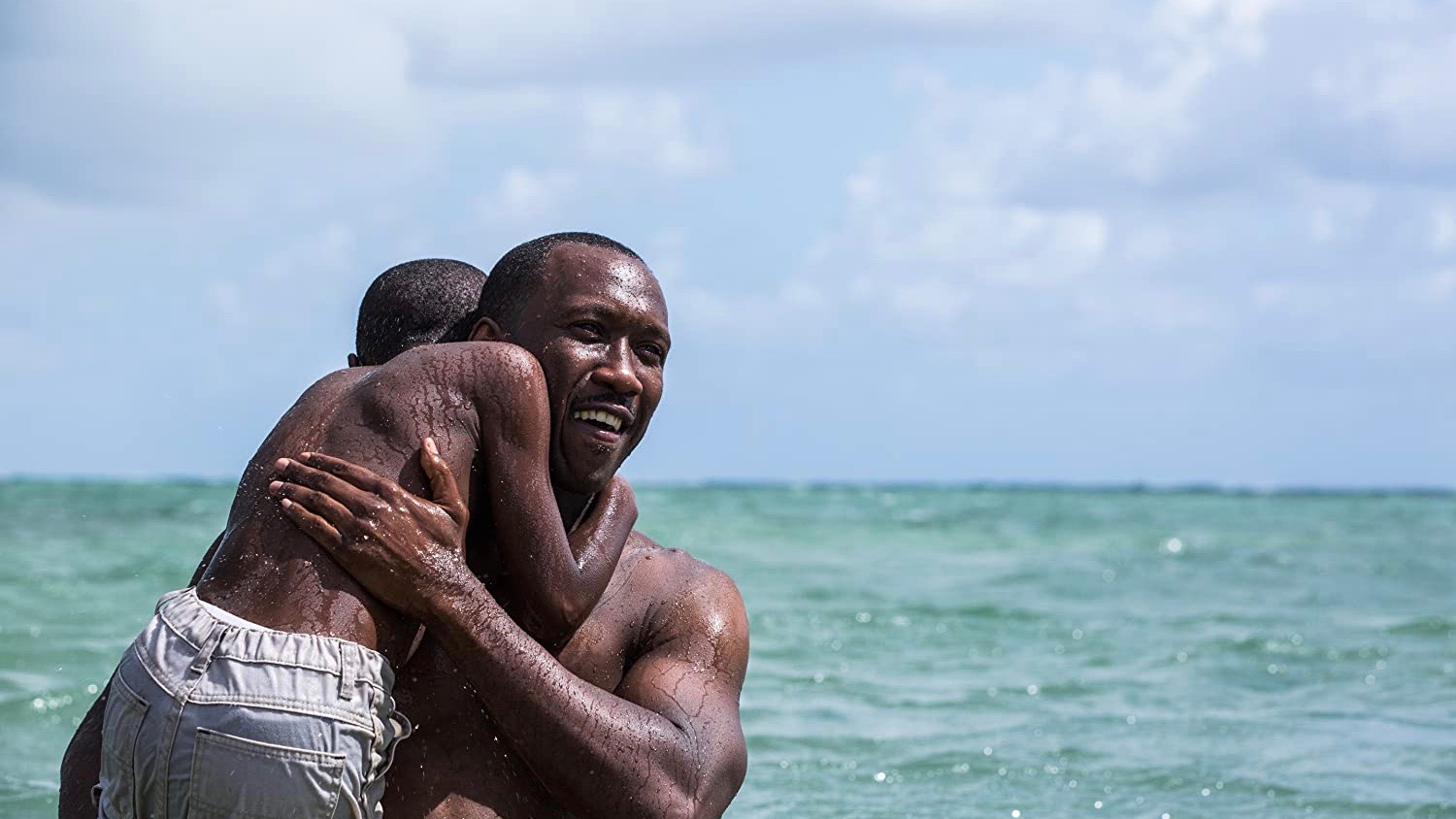 Mahershala Ali berce un enfant dans l’eau sur une image fixe du film Moonlight.