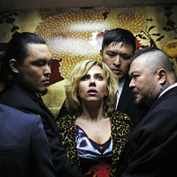 A woman is surrounded by three men in Lucy.