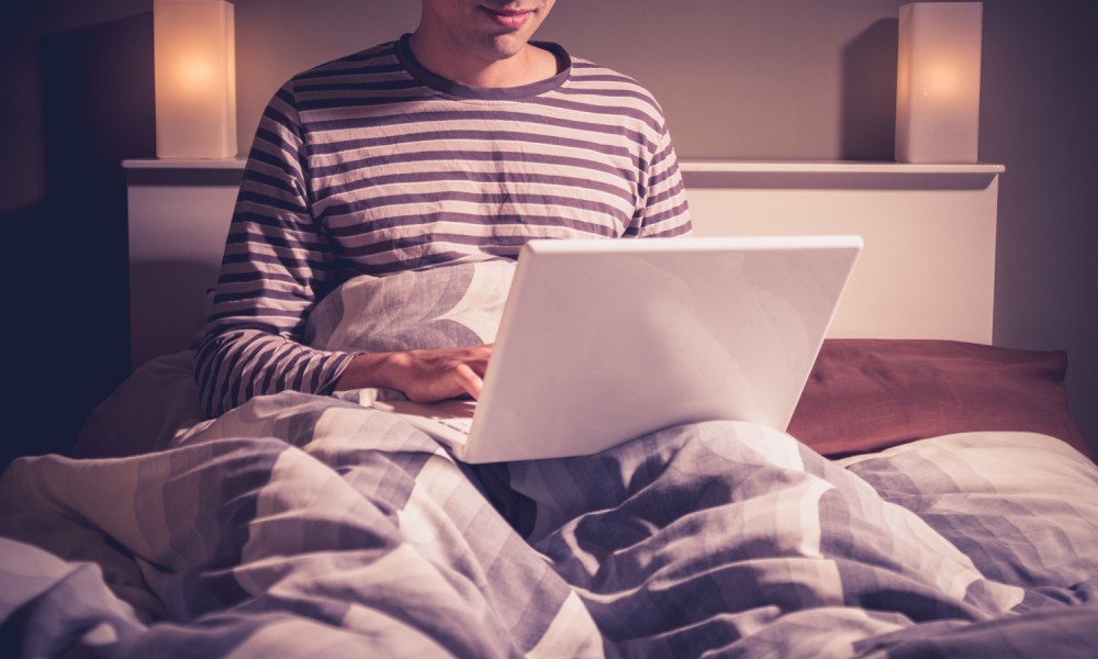 A person using a computer in bed.