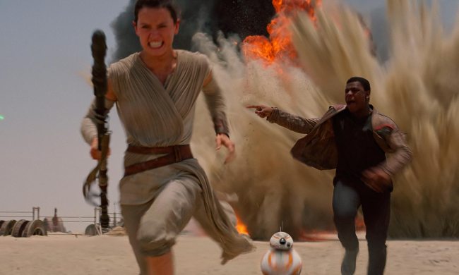 Rey runs from an explosion in Star Wars: The Force Awakens.