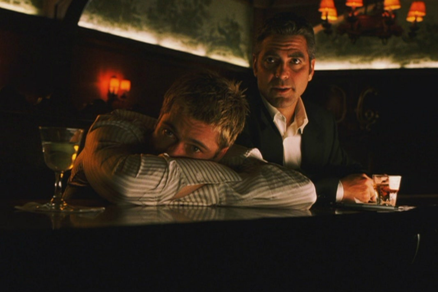 Brad Pitt and George Clooney sit at a bar in Ocean's Eleven.