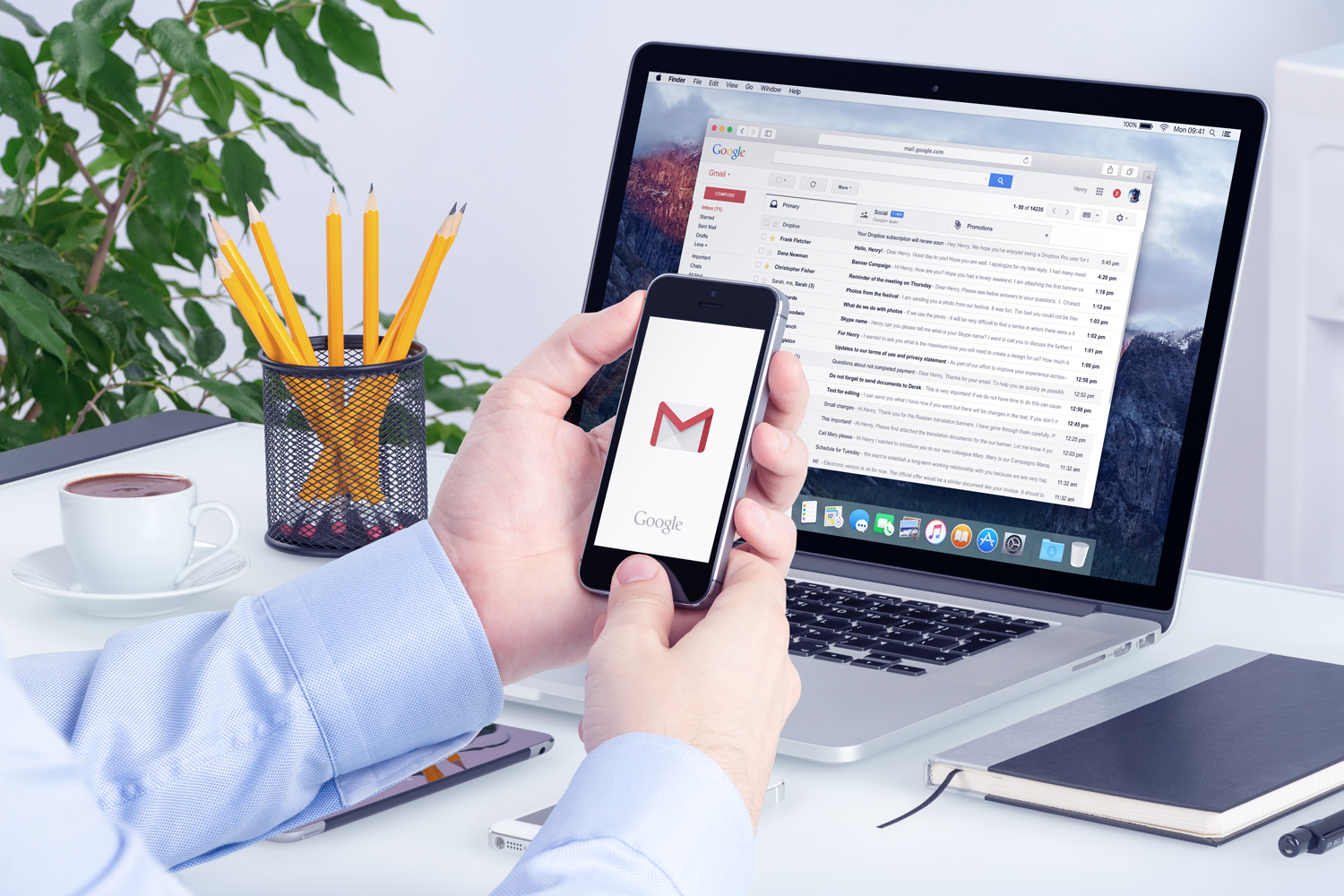 Una persona que accede a Gmail a través de su teléfono y computadora portátil.