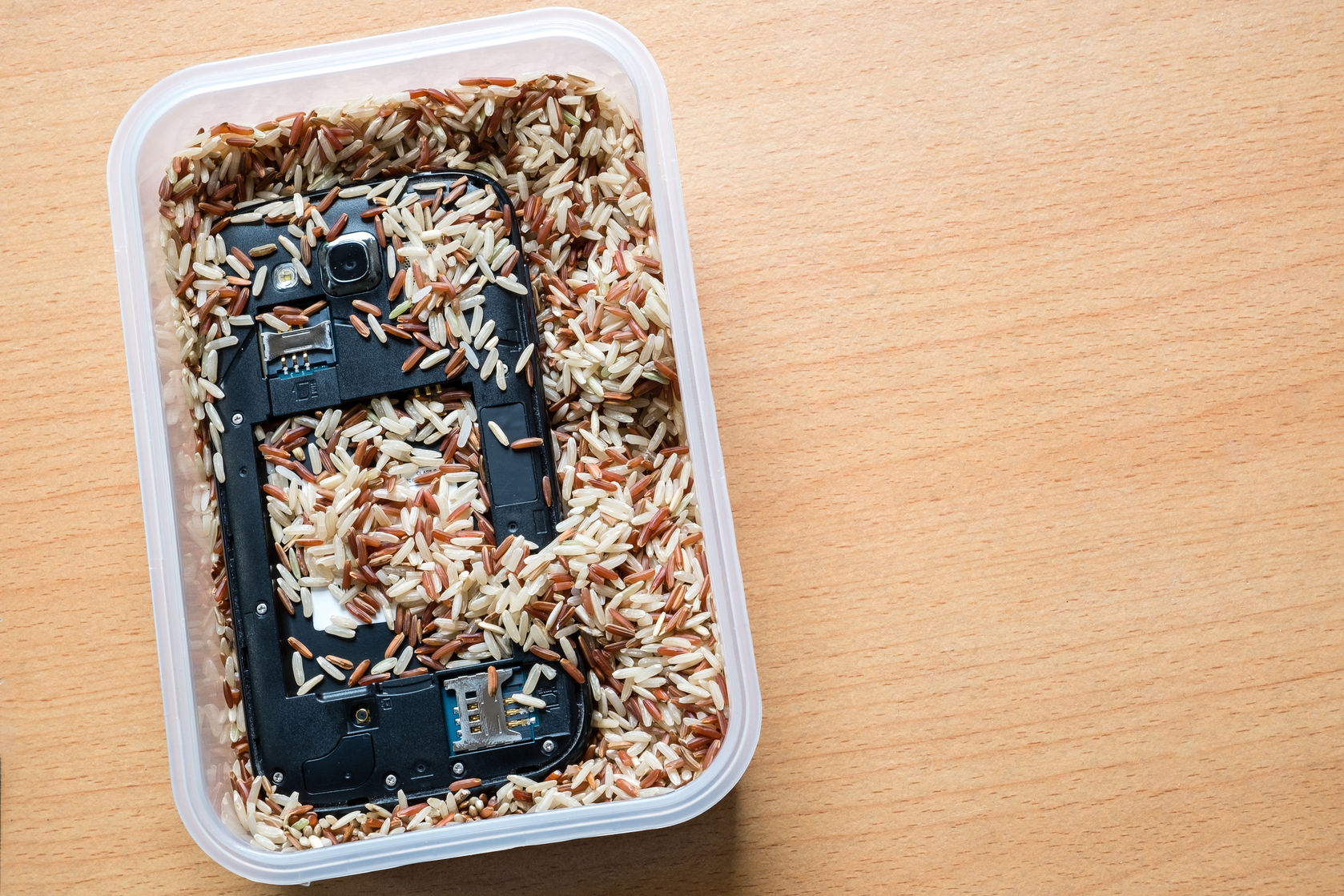 A smartphone immersed in rice.