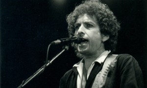 Bob Dylan sings into a microphone.