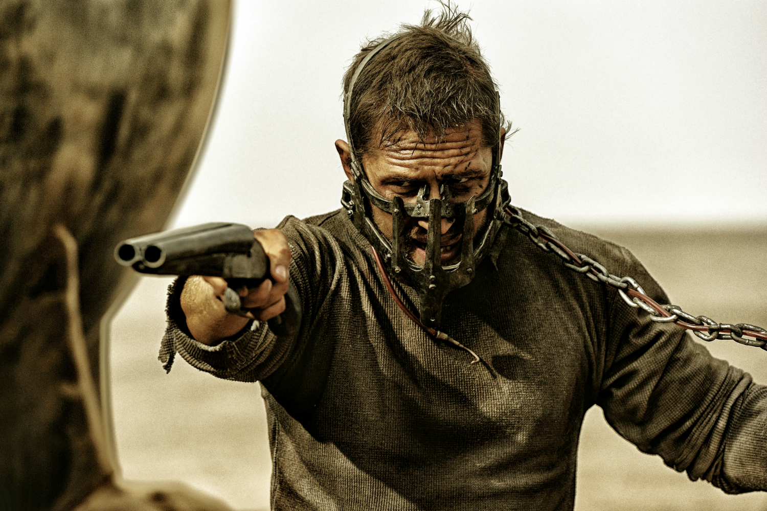 Mad Max aponta uma arma em Mad Max: Fury Road.