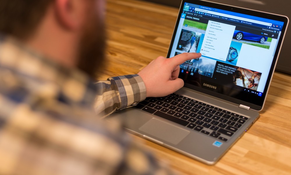 Man using Chromebook touchscreen.