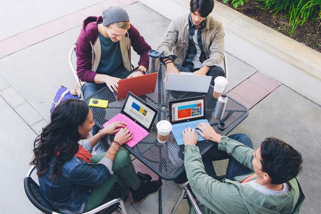 Students using Microsoft Office software on their laptops outside.