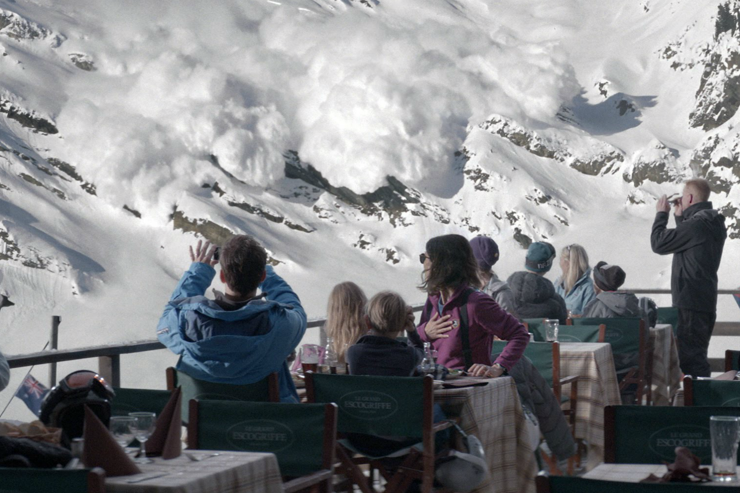 Un groupe de personnes regarde une avalanche.