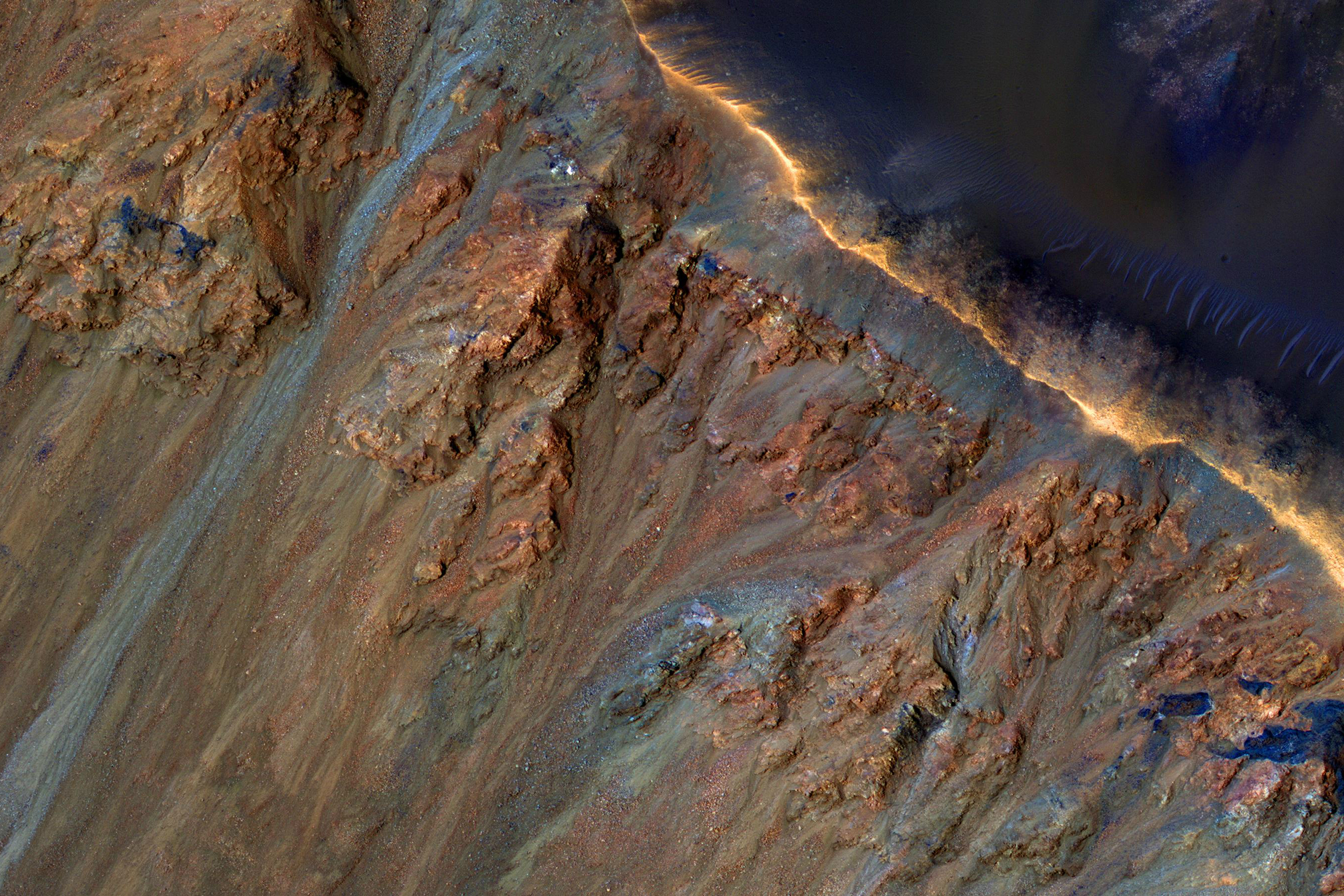 Although large gullies (ravines) are concentrated at higher latitudes, there are gullies on steep slopes in equatorial regions, as seen in this image captured by NASA's Mars Reconnaissance Orbiter (MRO). An enhanced-color closeup shows part of the rim and inner slope of Krupac Crater located just 7.8 degrees south of the equator.