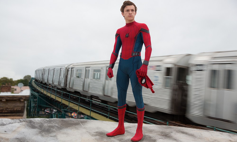 Spider-Man with his mask off standing atop a train in Spider-Man: Homecoming.