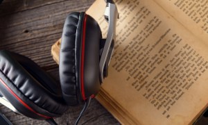 A pair of headphones with a book.