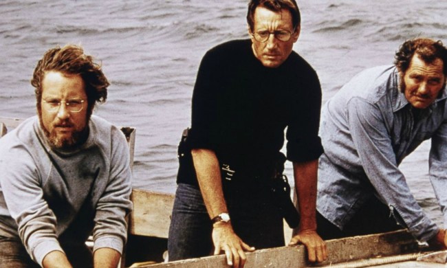 Three men stand in a boat and stare into the ocean in Jaws.