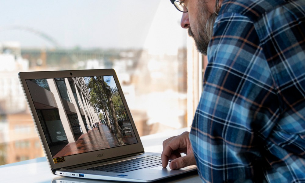 A person sitting at an Asus Chromebook 15 and using it.