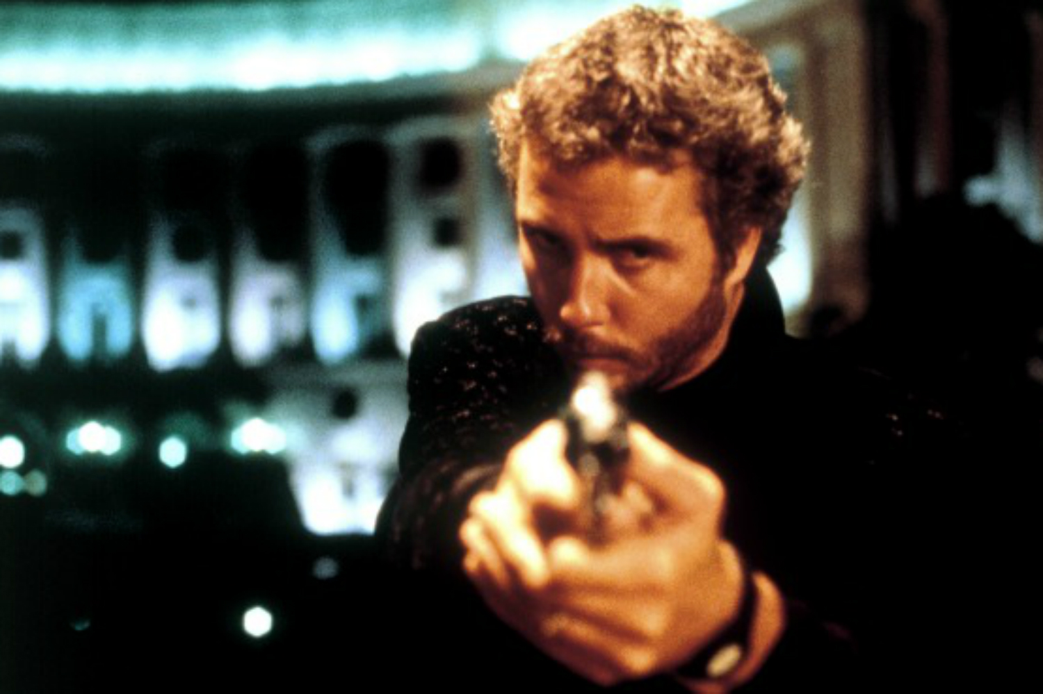 William Peterson pointe une arme et regarde Manhunter.