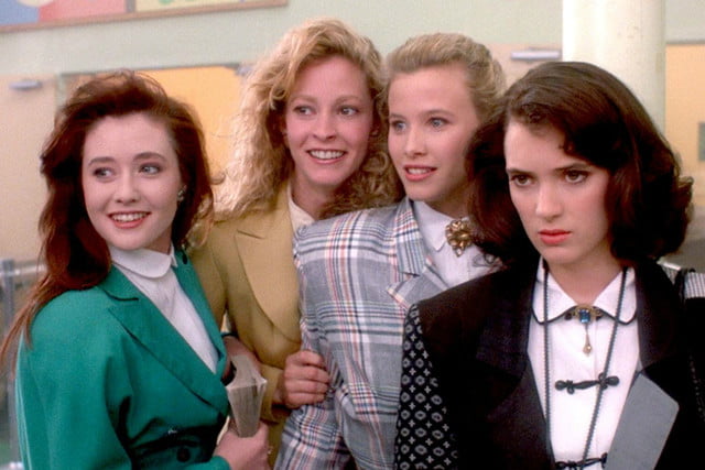 Four teen girls stand and stare in Heathers.