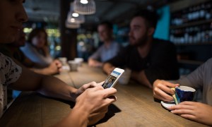 man with iPhone at bar