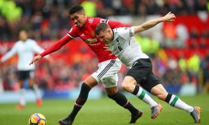 Premier League soccer match with two players tussling for the ball.