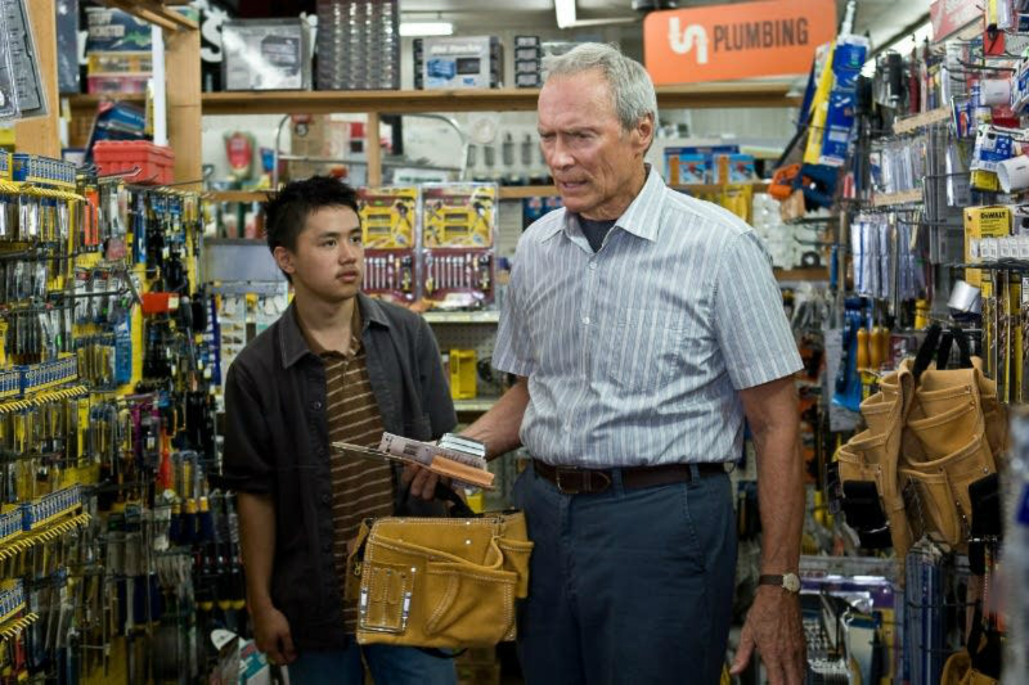 Clint Eastwood se tient à côté d'un jeune garçon à Gran Torino.