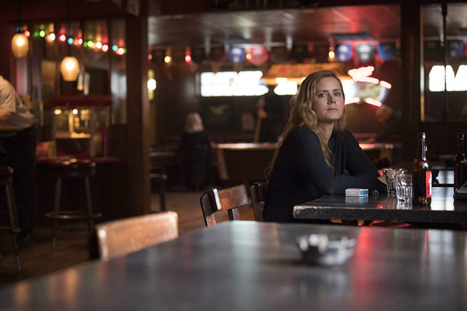 Amy Adams sentada em um bar em Sharp Objects (HBO)