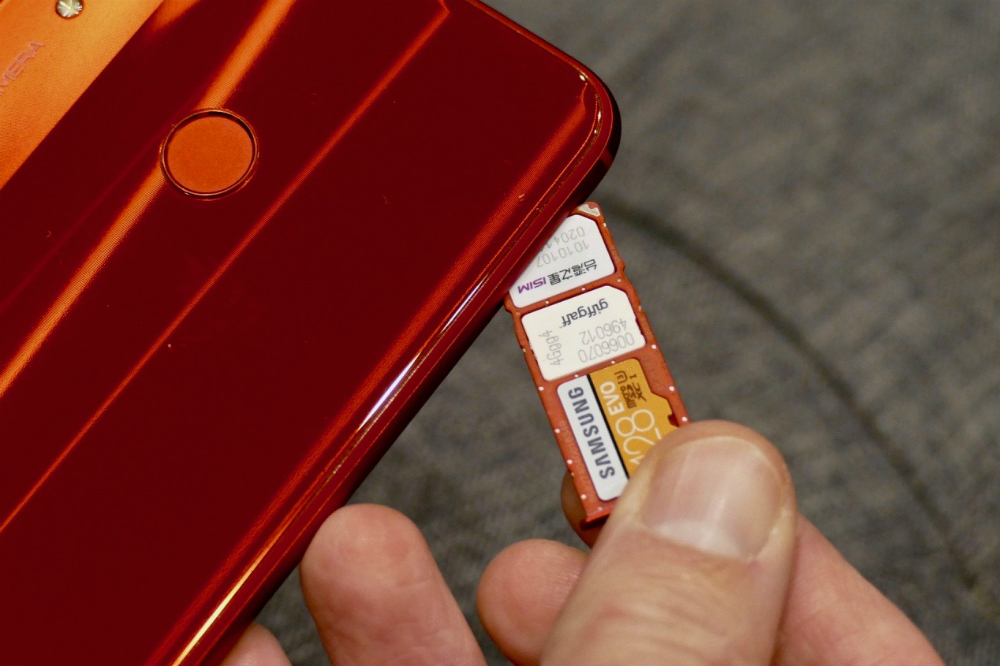 A SIM card next to a smartphone.