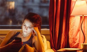 A person reading next to smart light bulb.