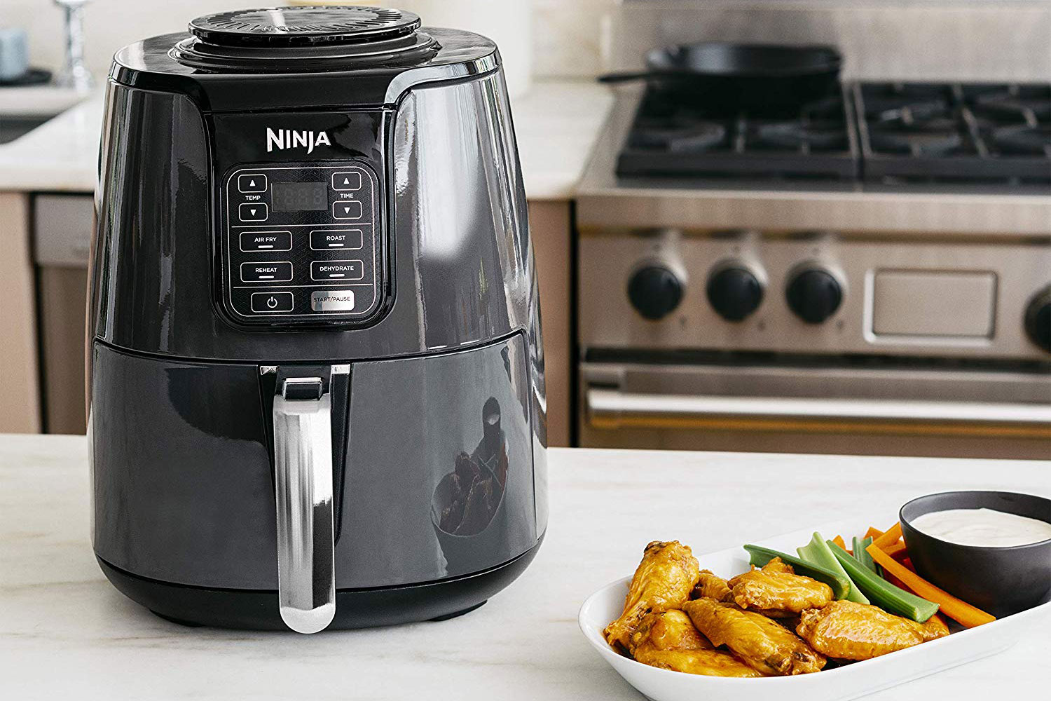 The Ninja 4-Quart Air Fryer with cooked food at the side.