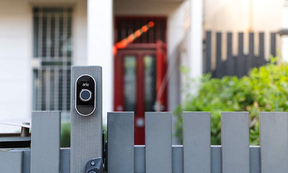 Arlo Smart Home Security Kit with An Arlo Pro Camera on fence.