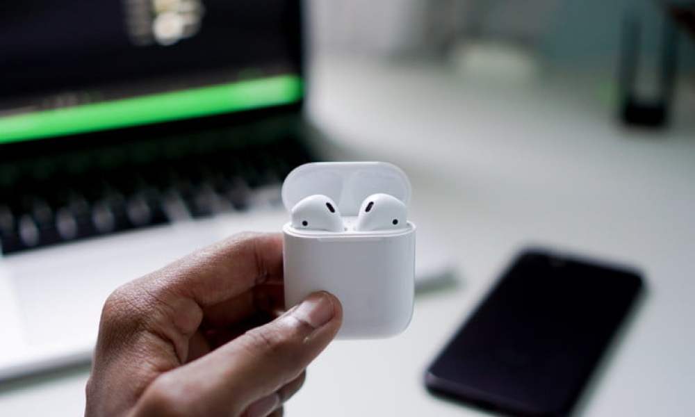 Apple AirPods held in hand.