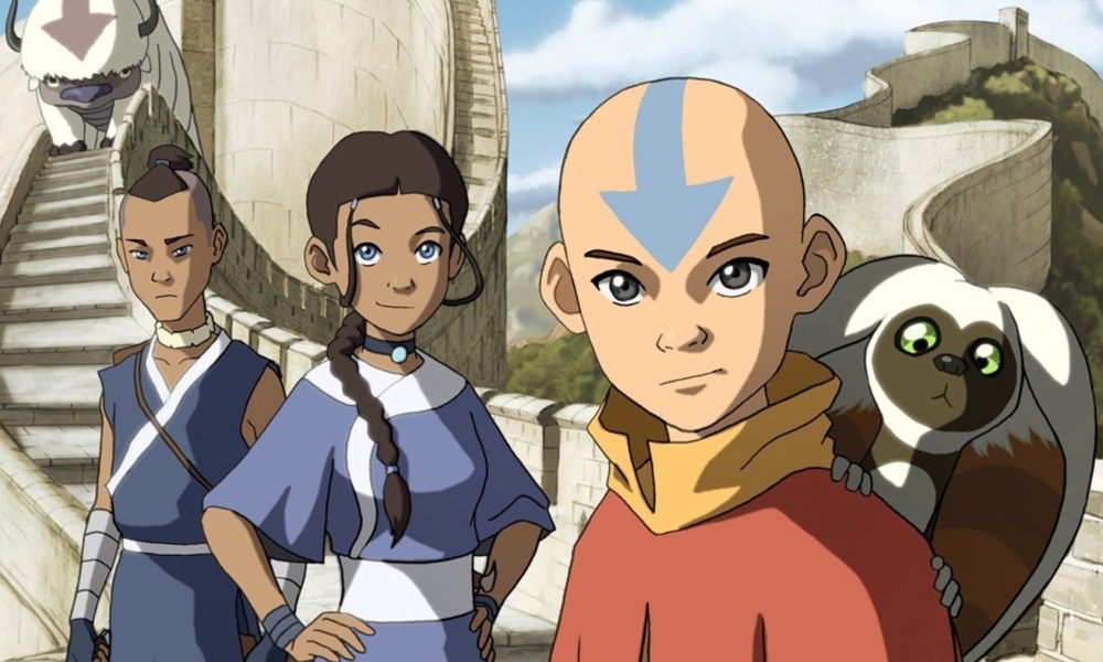 Sokka, Katara, and Aang standing and looking at the camera. Momo is on Aang's shoulder.