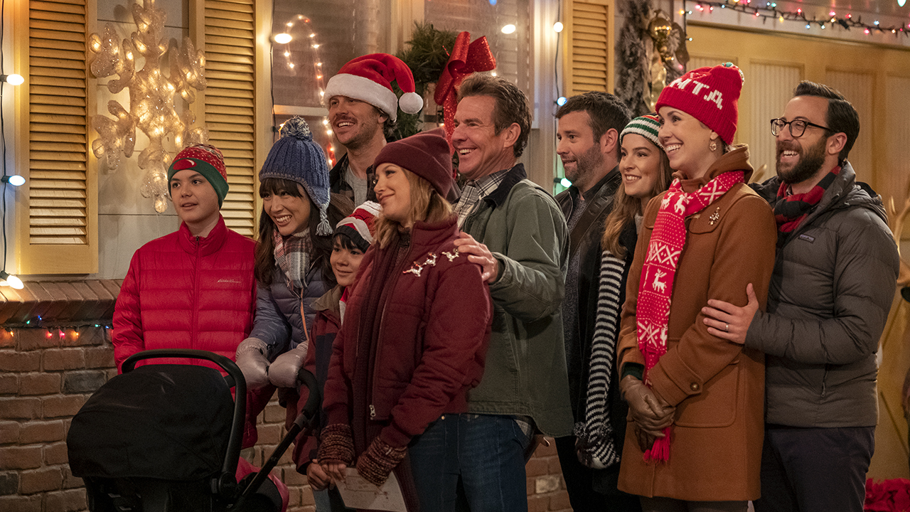 Un groupe de personnes chantent des chants de Noël dans Merry Happy Which.