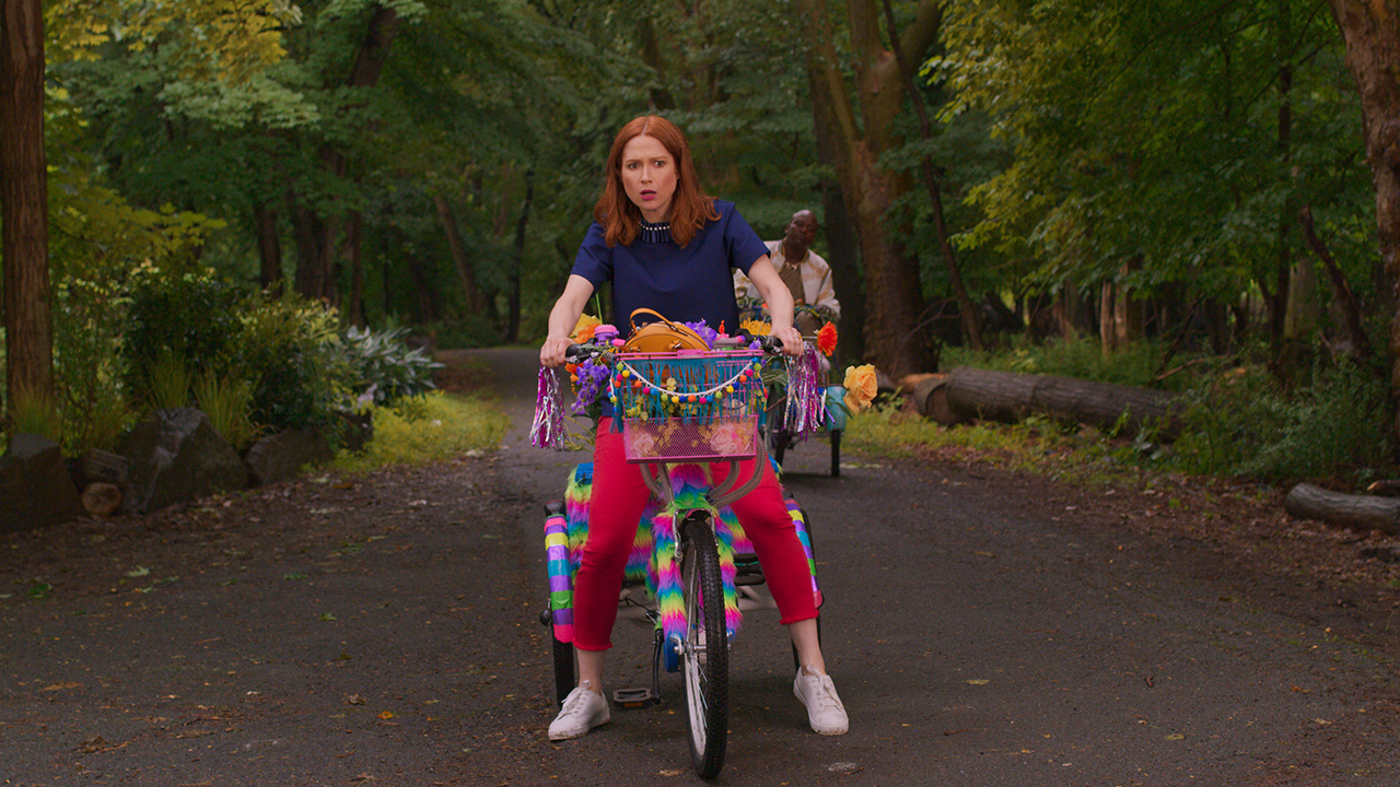 Kimmy Schmidt dans Unbreakable Kimmy Schmidt faisant du vélo.