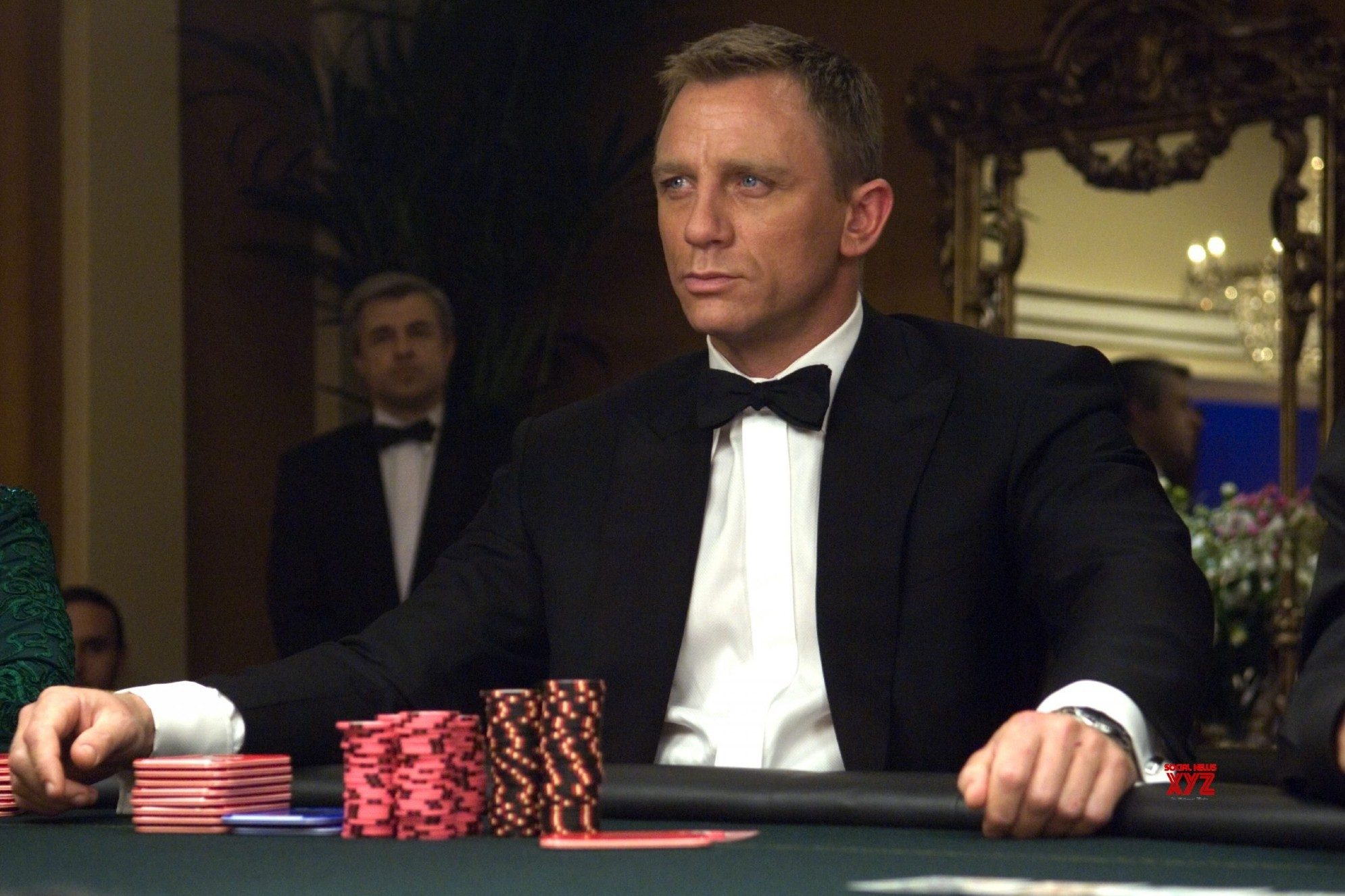 Daniel Craig está sentado em uma mesa de pôquer no Casino Royale.