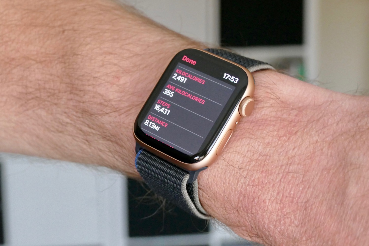 Apple Watch SE on a person's wrist shows a weekly health-tracking summary.