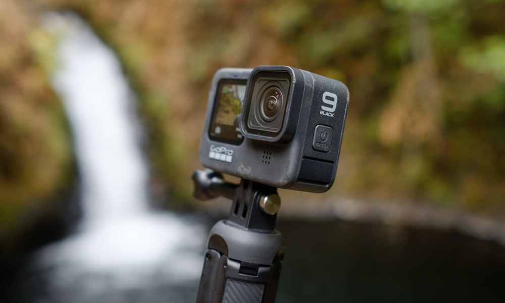 The GoPro Hero 9 Black with a waterfall in the background.