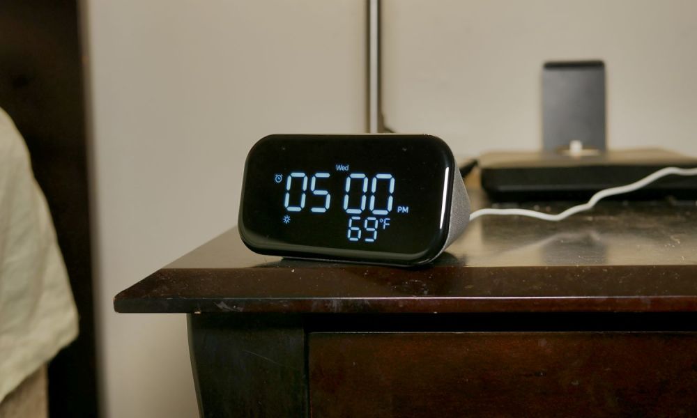 A Lenovo Smart Clock 2 placed on a bedside table.