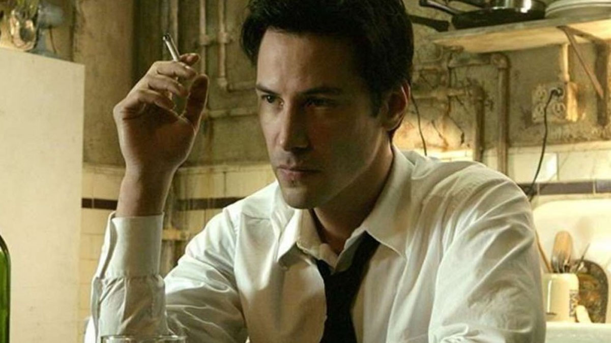 Keanu Reeves fume une cigarette dans le rôle de John Constantine dans une photo du film Constantine.