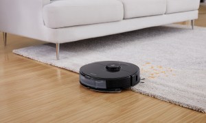 Roborock S7 robot vacuum cleaning a rug on a hardwood floor.