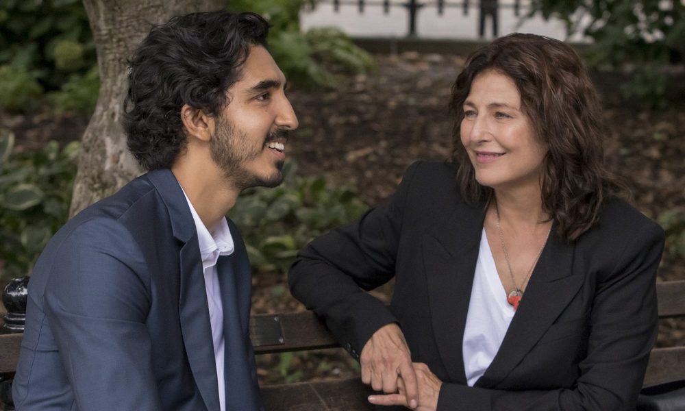 A man and a woman sit on a bench with each other.