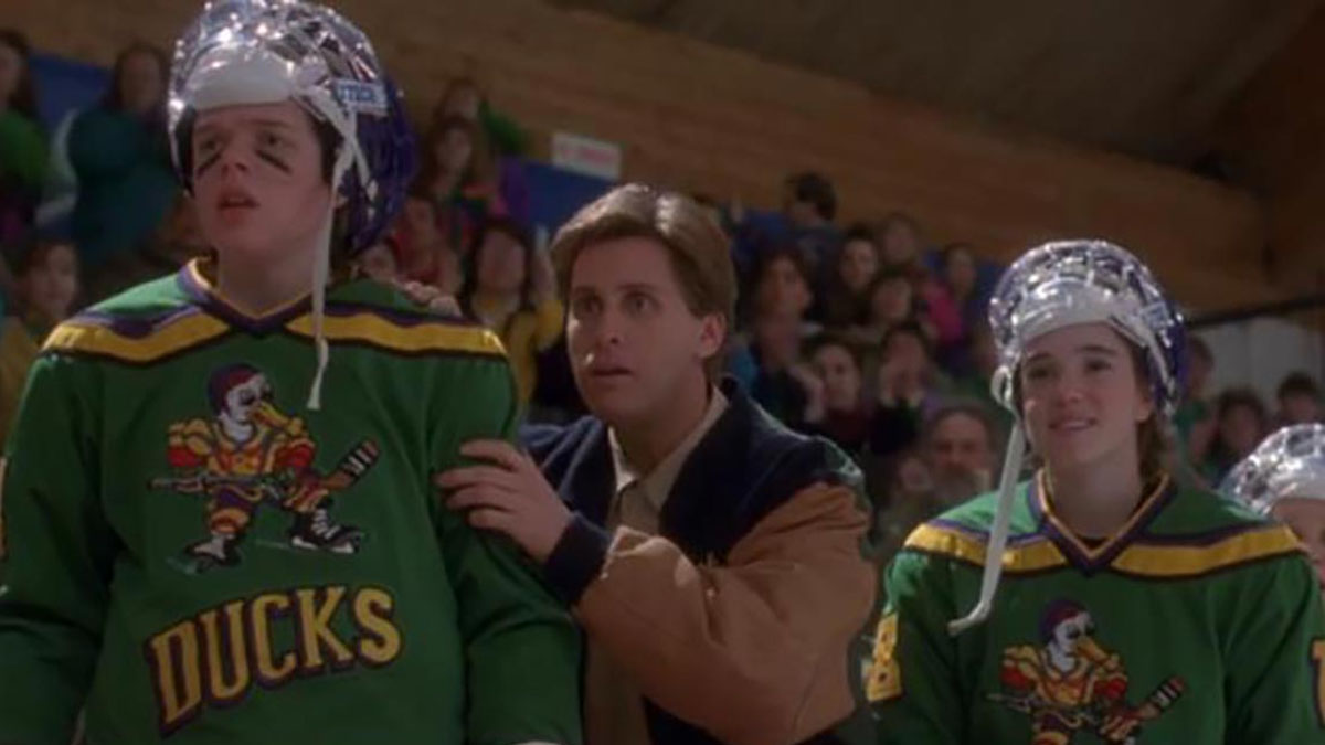 Тренер стоит рядом со своими игроками на боковой линии в The Mighty Ducks.