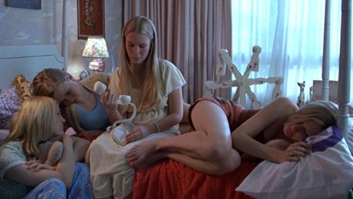 Un groupe de filles qui semblent s'ennuyer dans une chambre dans The Virgin Suicides