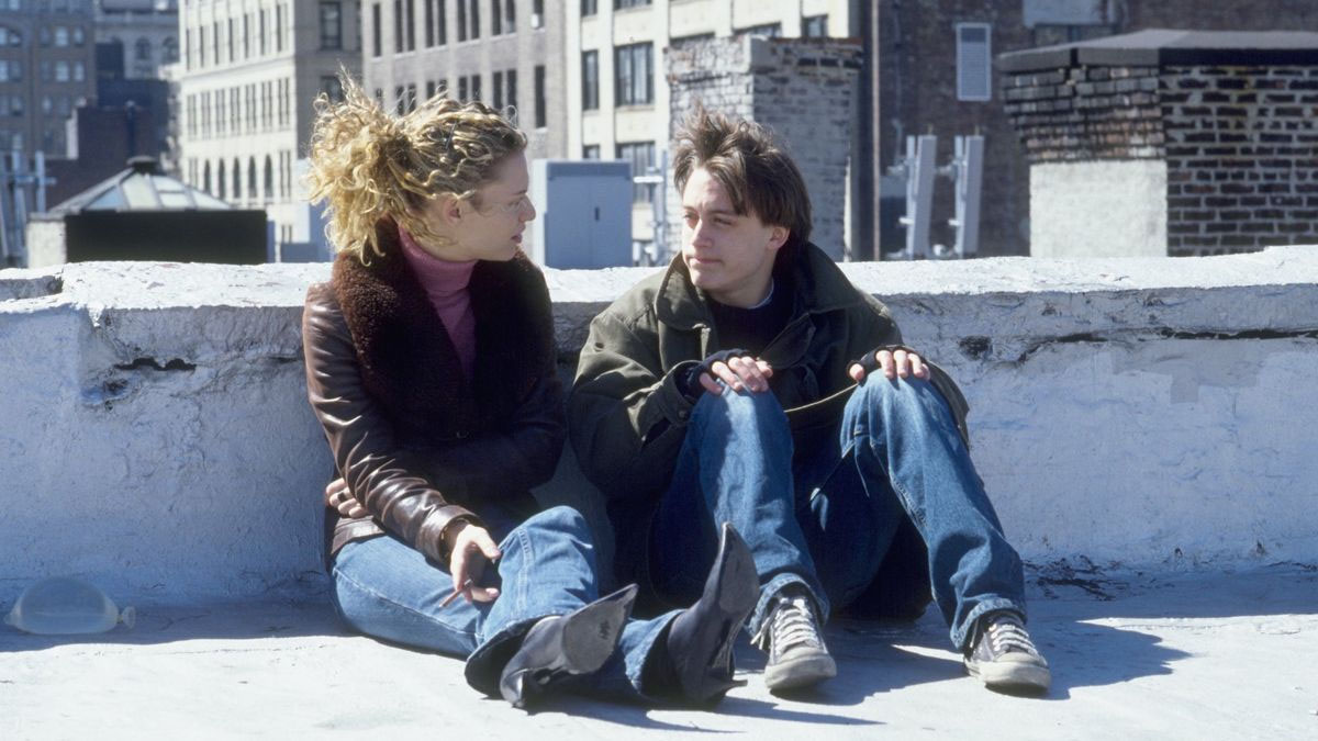 Claire Danes e Kieran Culkin como Sookie e Igby sentados em uma rua conversando em Igby Goes Down.