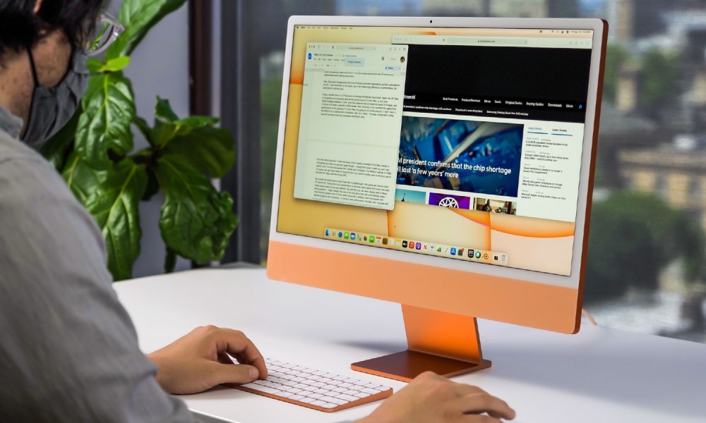 Man using a 24-inch M1 iMac.