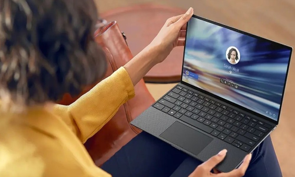 Person sitting and holding Dell XPS 13 laptop on their lap.