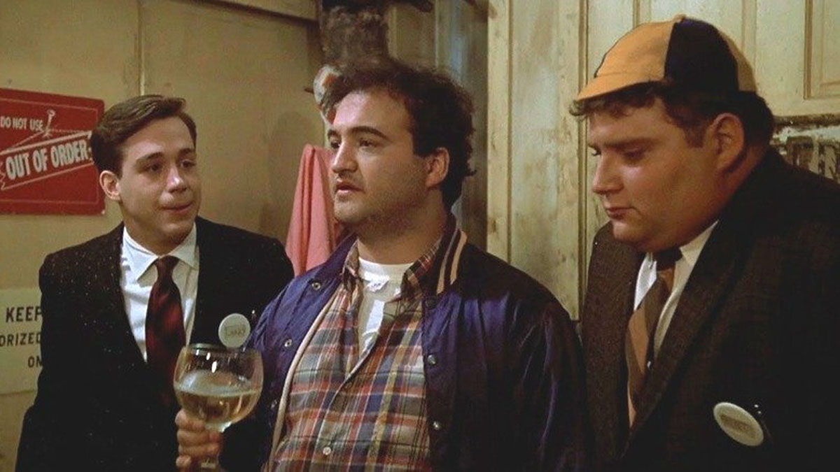 The cast of Animal House stand up against a wall.