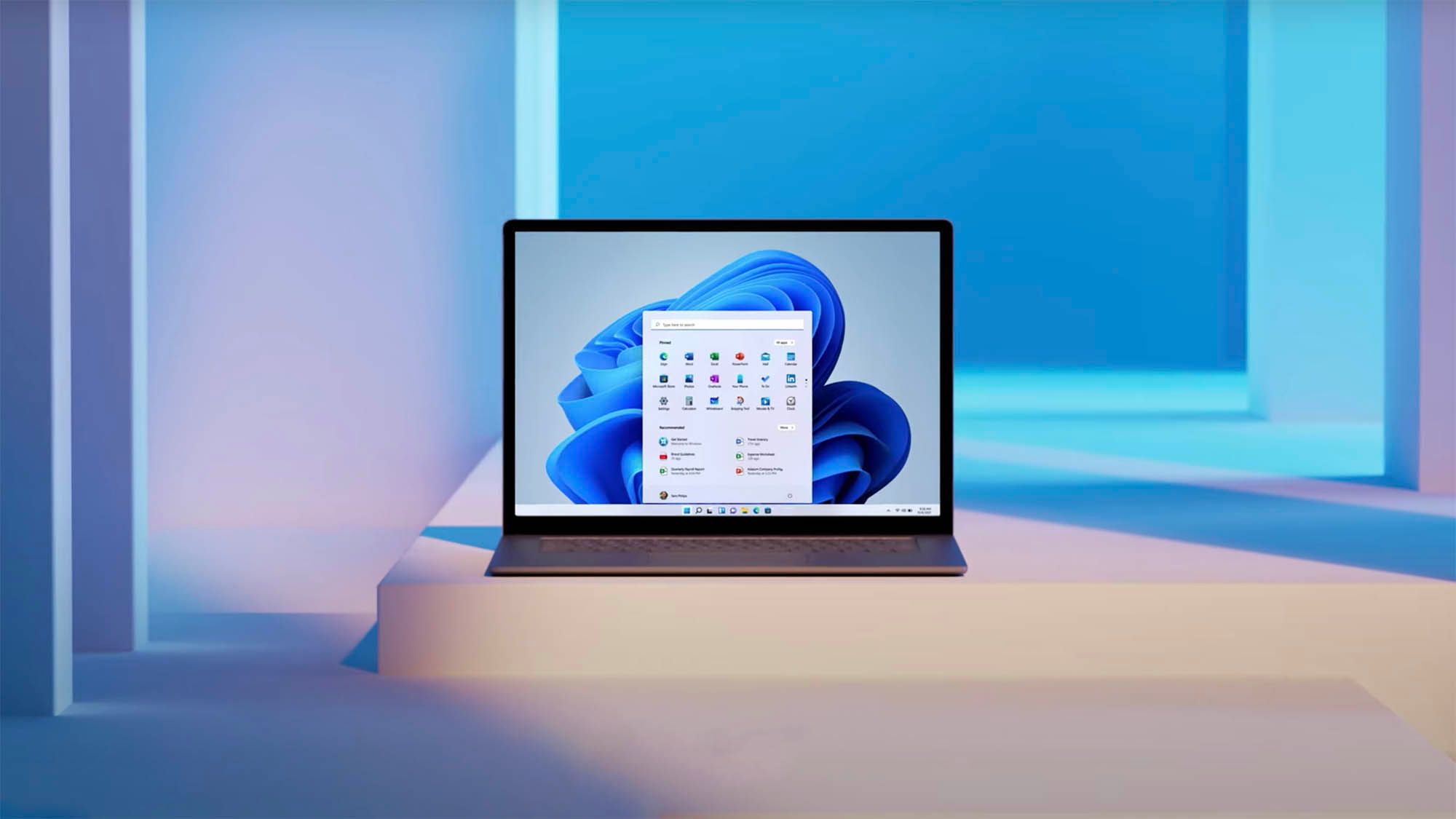 A laptop sits on a white step, surrounded by white and blue lighting.  It runs Windows 11.