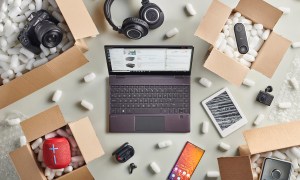 Laptop on Amazon surrounded by boxes of tech gear.