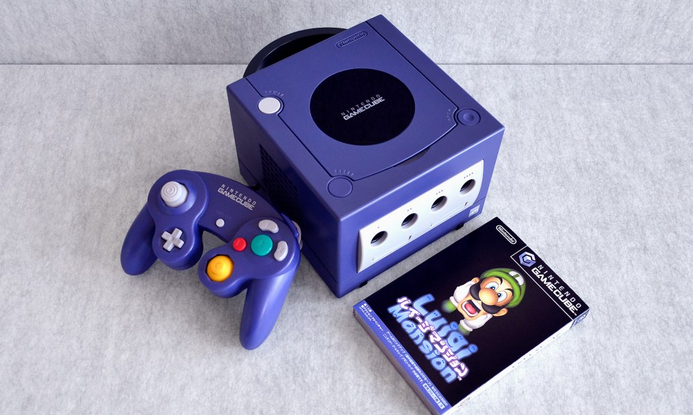 A Nintendo GameCube sits on a table with Luigi's Mansion.