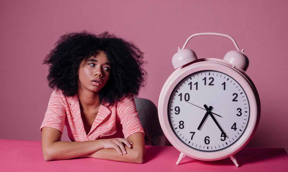 woman stares at large alarm clock