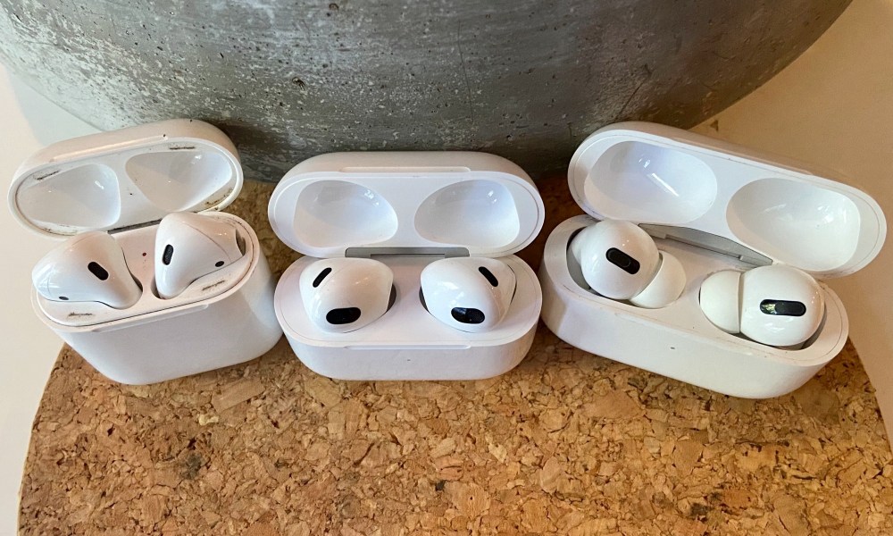 AirPods 3, AirPods, and AirPods Pro sitting in their charging cases.