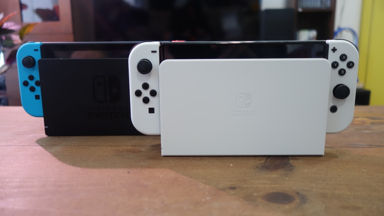 Un modelo OLED de Nintendo Switch en su base junto a una base normal de Switch.